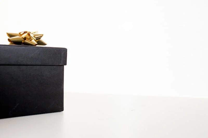 Black kraft rigid gift box with gold bow for luxury brand packaging