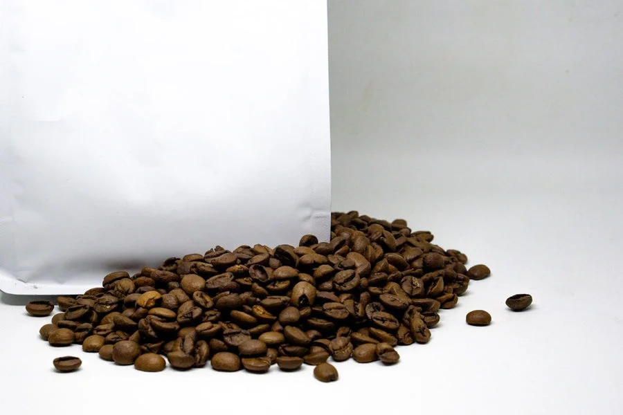 Coffee beans beside a custom coffee pouch