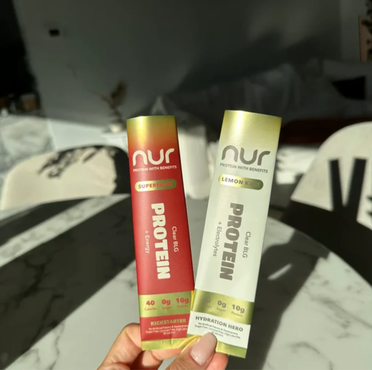 NUR protein stick packs held in natural light