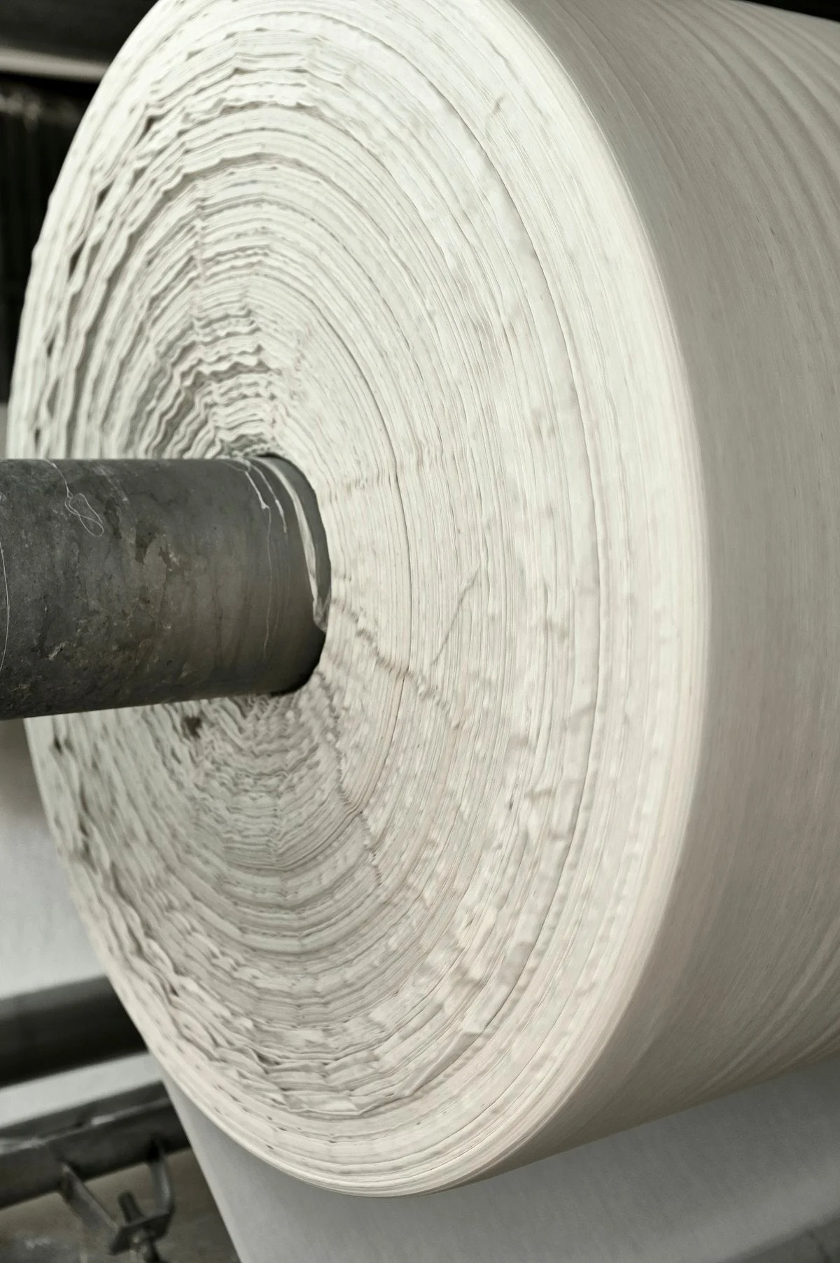 Industrial paper manufacturing machine with large roll of paper being produced
