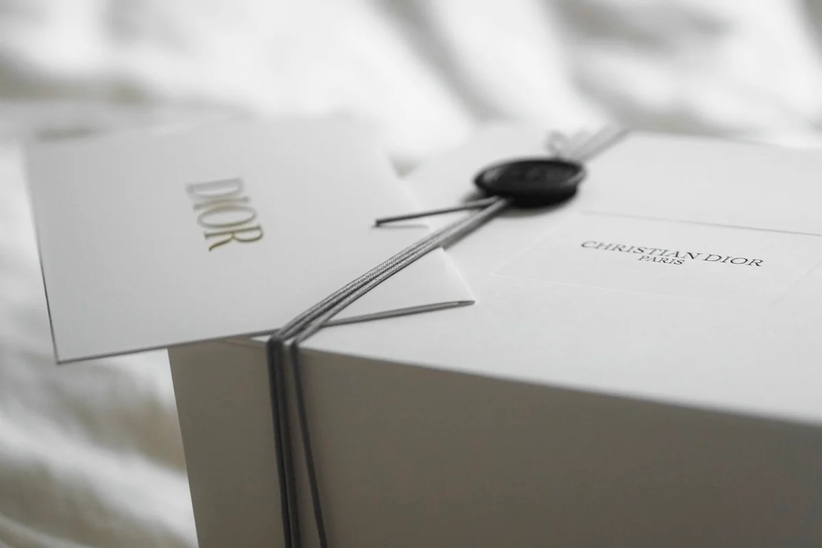 Dior luxury gift box with ribbon and tag representing premium brand packaging across industries