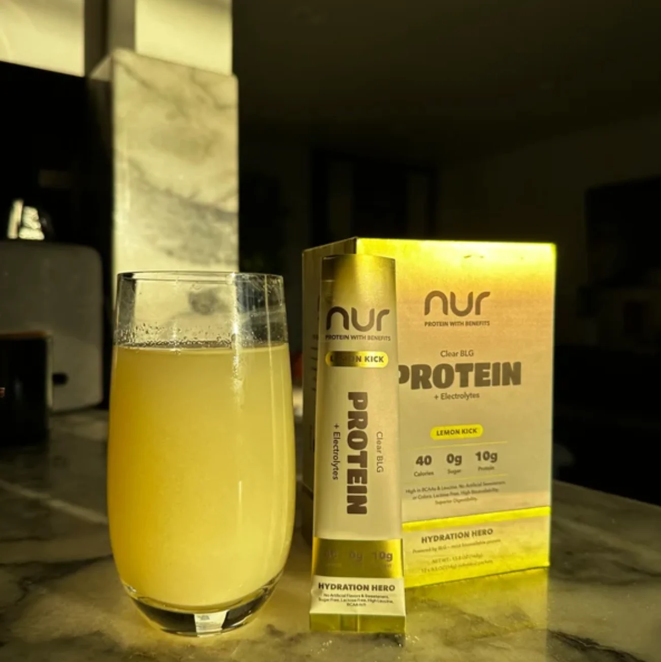 NUR protein packaging beside a yellow protein drink