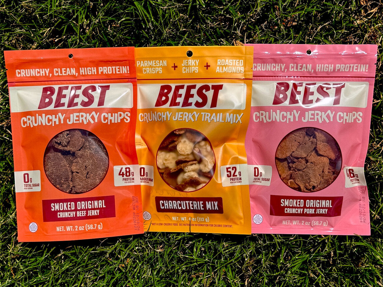 Three clear-window BEEST pouches: beef jerky chips, charcuterie mix, and pork jerky chips.