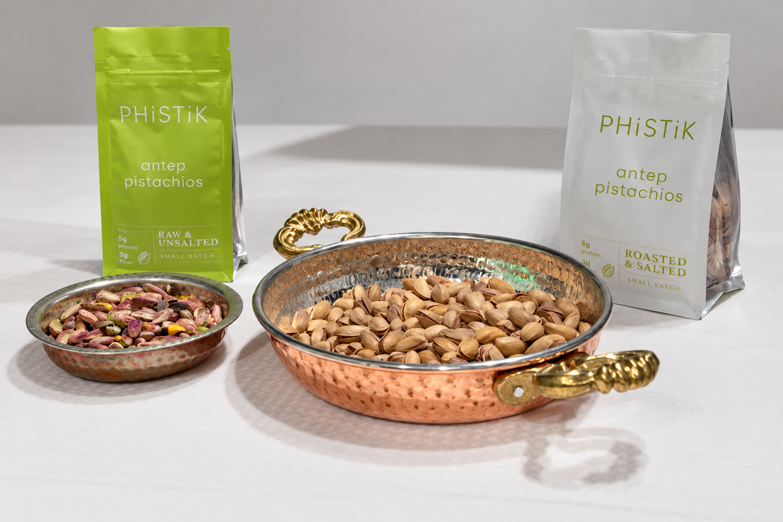 PHiSTiK raw and roasted pistachio pouches displayed with pistachios