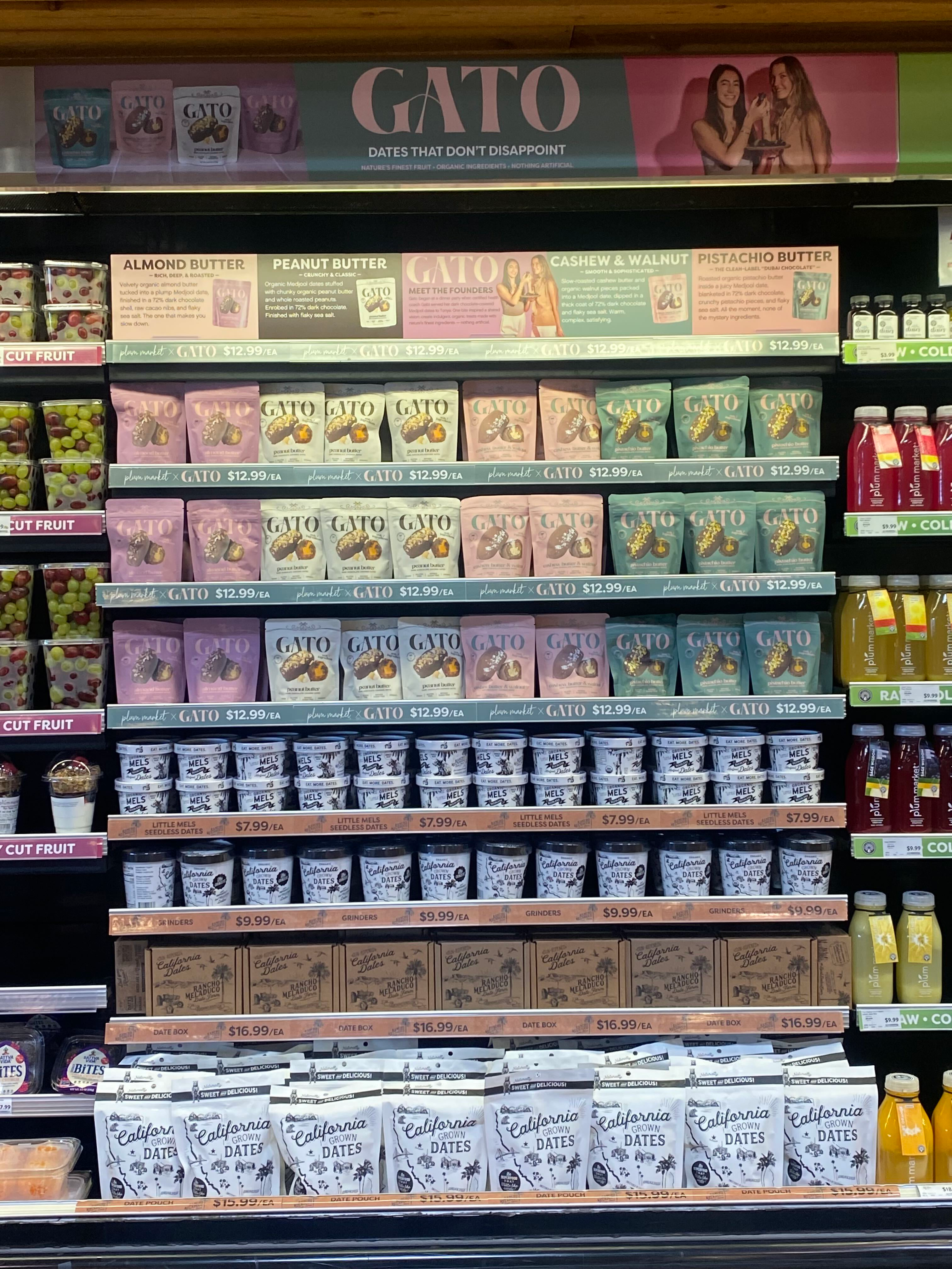 Gato chocolate-covered date pouches in multiple flavors displayed in a refrigerated retail case with Gato signage.