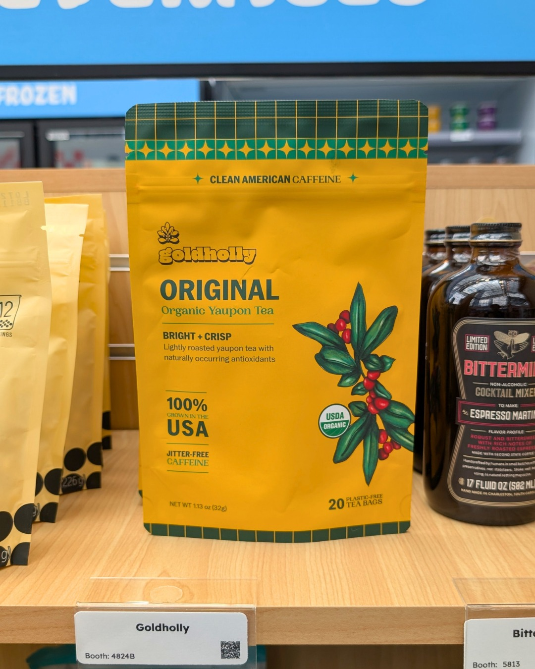 A yellow Goldholly Original Organic Yaupon Tea pouch displayed on a wooden shelf.