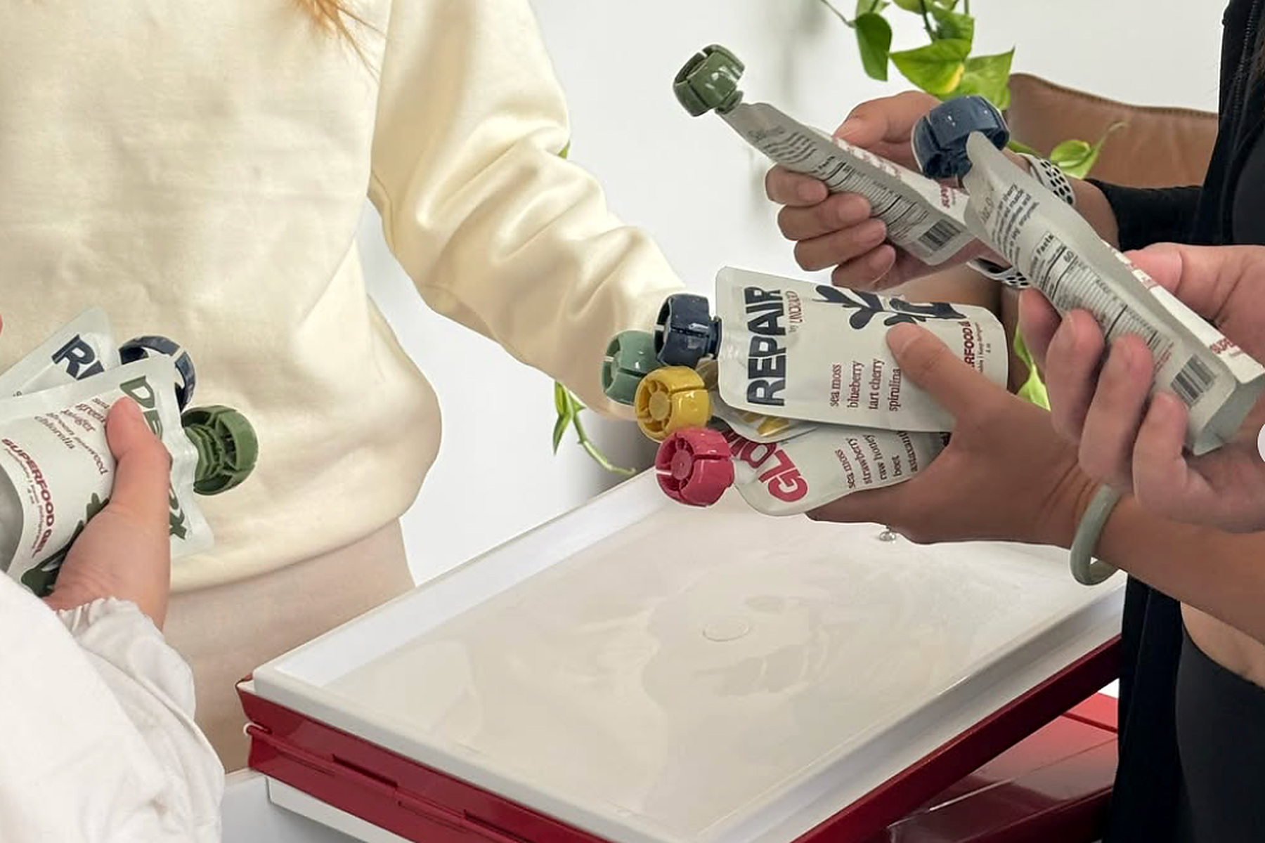 Several people hold Uncracked spouted pouches during a product sampling session.