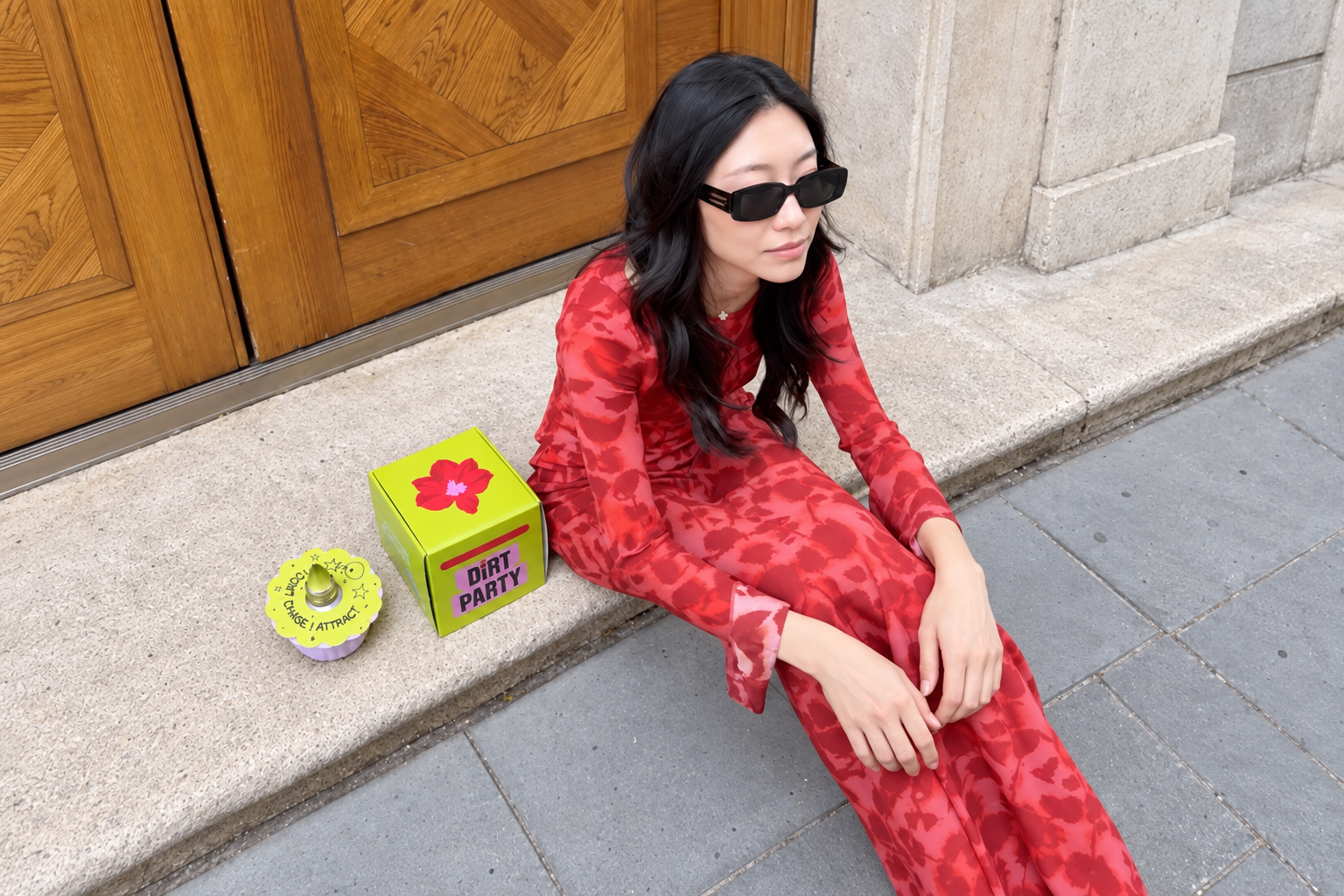 A woman seated outside beside a Dirt Party box and waxed amaryllis bulb