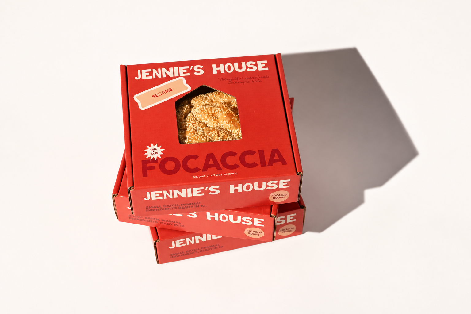 Red Jennie's House focaccia cartons are stacked under strong studio light.