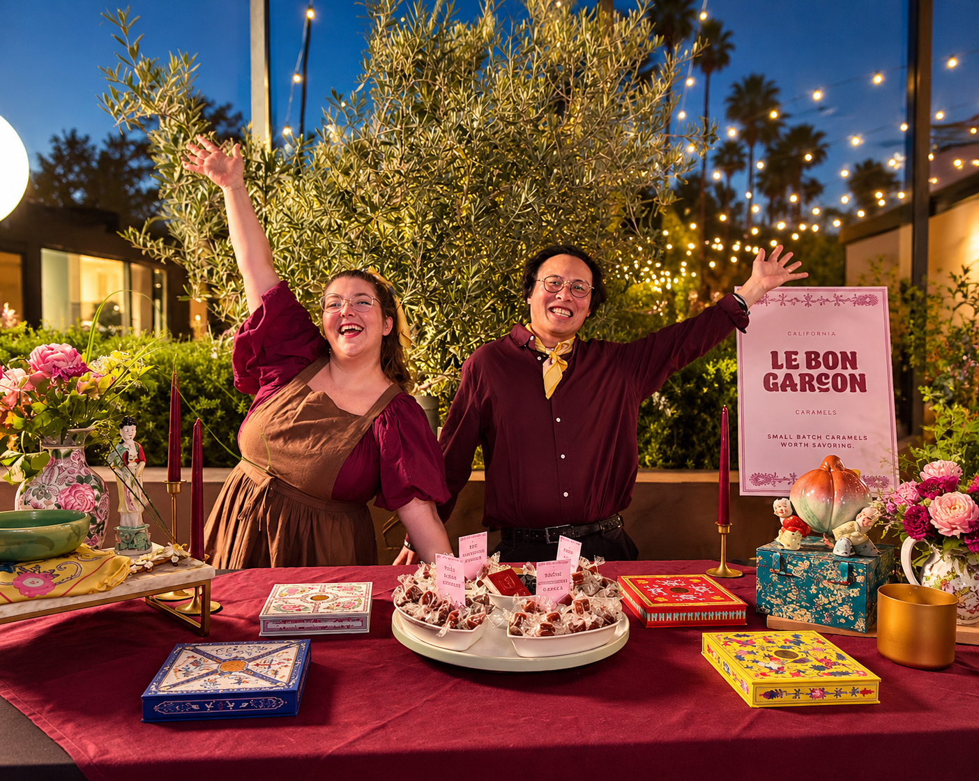 Two Le Bon Garçon team members stand behind a caramel display at an outdoor event.